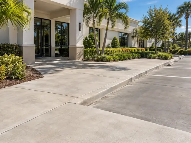 Concrete entrance walkway and parking surface outside a low-rise commercial building