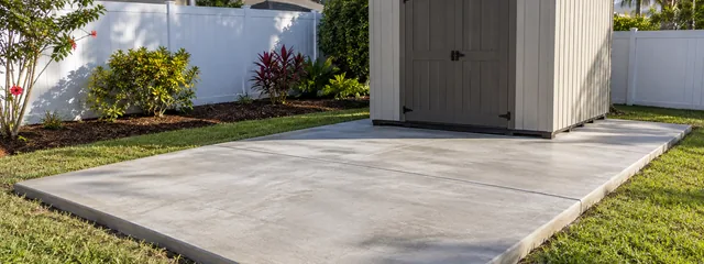 Rectangular concrete pad supporting a backyard storage shed